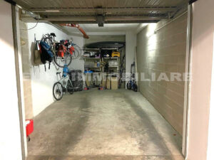 Garage spazioso in un pentalocale a Milano, organizzato con scaffalature e ganci per biciclette.