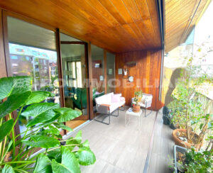 Balcone arredato con piante e mobili moderni in un appartamento a Milano.