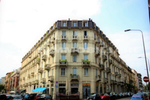 Vista elegante dell'angolo di un tradizionale edificio di appartamenti milanese con dettagli ornamentali.
