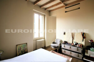 Camera da letto confortevole e accogliente con luce naturale e arredo minimalista in un appartamento a Milano.