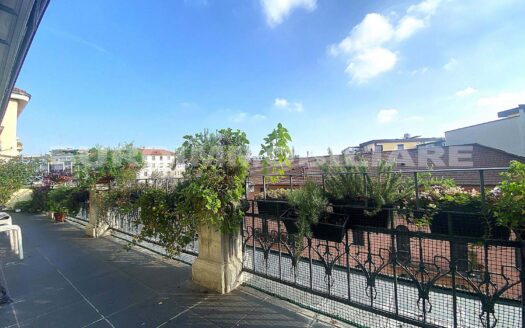 Terrazza panoramica in vendita a Milano con rigogliosa vegetazione e vista sui tetti, ideale per relax all'aperto